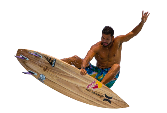 A man sticking his tongue out while riding a surfboard