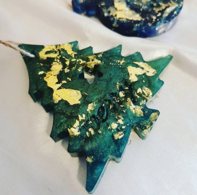 Large, metallic gold flecks add vibrancy to this green epoxy-casted pine tree ornament.