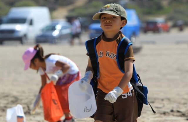 Two youngsters hard at work cleaning up a beach on Kids Ocean Day.